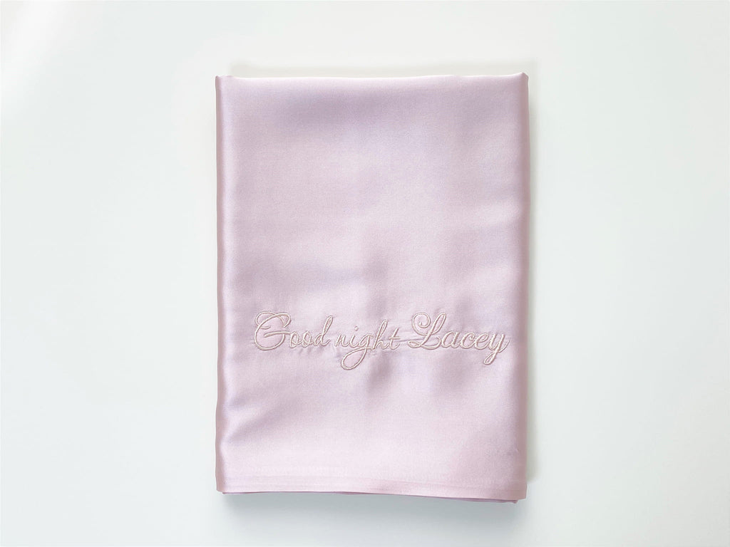 Folded pink silk pillowcase with personalized embroidery