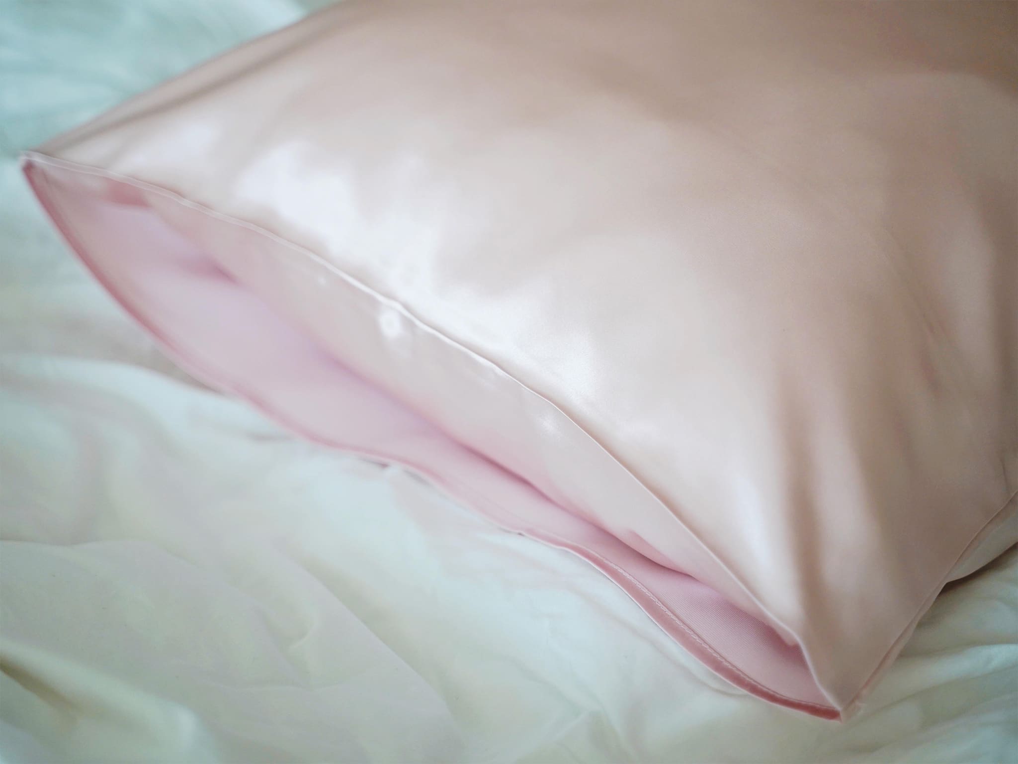 Close-up of pink 22 momme double sided mulberry silk pillowcase on bed