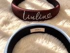 Inner view of personalized silk padded headband showing 100% silk label on a soft plush background.