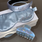 Personalized silk sleep set with custom rhinestone names, featuring a silk headband, sleep mask, and claw clip gift set.