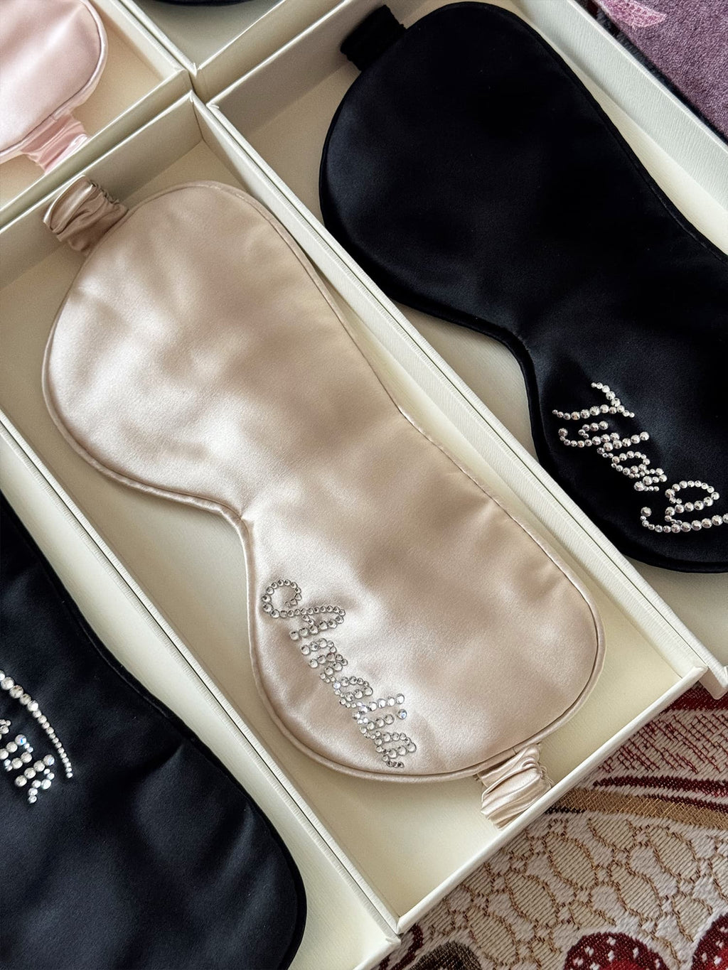 Champagne 22 momme silk sleep mask with custom rhinestone name displayed in gift box.