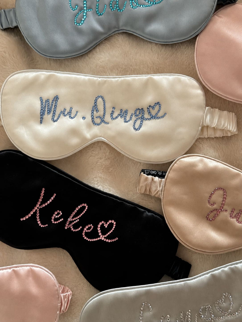 Personalized 22 momme silk sleep masks with custom rhinestone names in assorted colors.