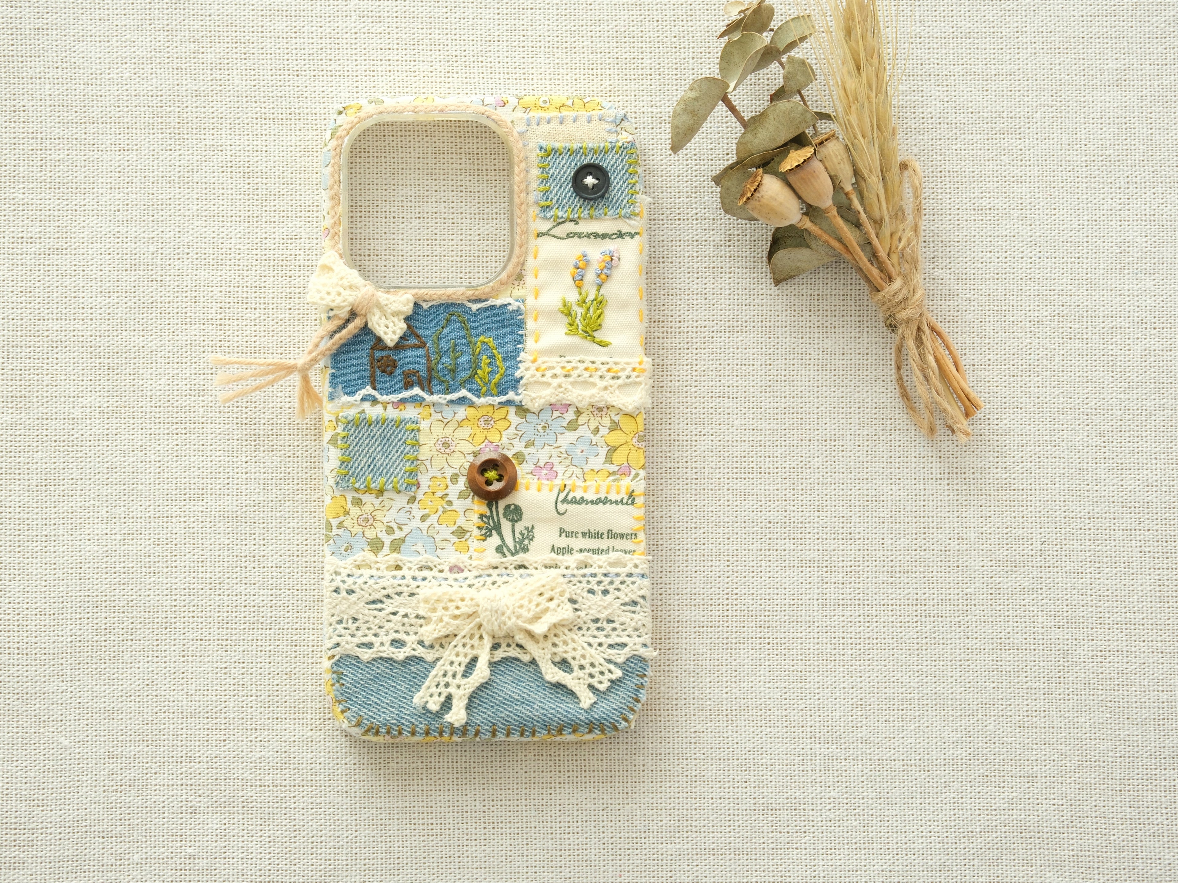Cottagecore style patchwork case with dried flowers on a linen background, handcrafted vintage design.