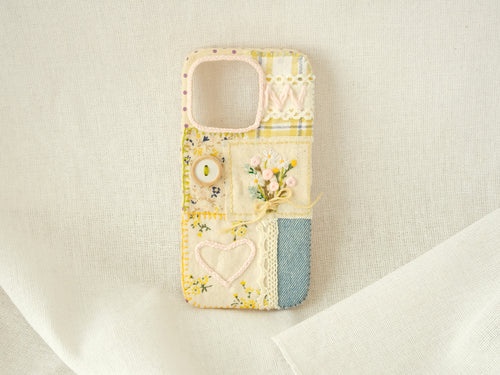 Handmade patchwork phone case with a floral heart, embroidered daisies, and lace, vintage romantic style.