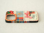 Side view of the cherry patchwork case with button access and colorful plaid fabric texture.