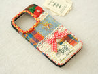 Side view of the patchwork case featuring 3D cherries, a red bow, and a hand-braided camera border.