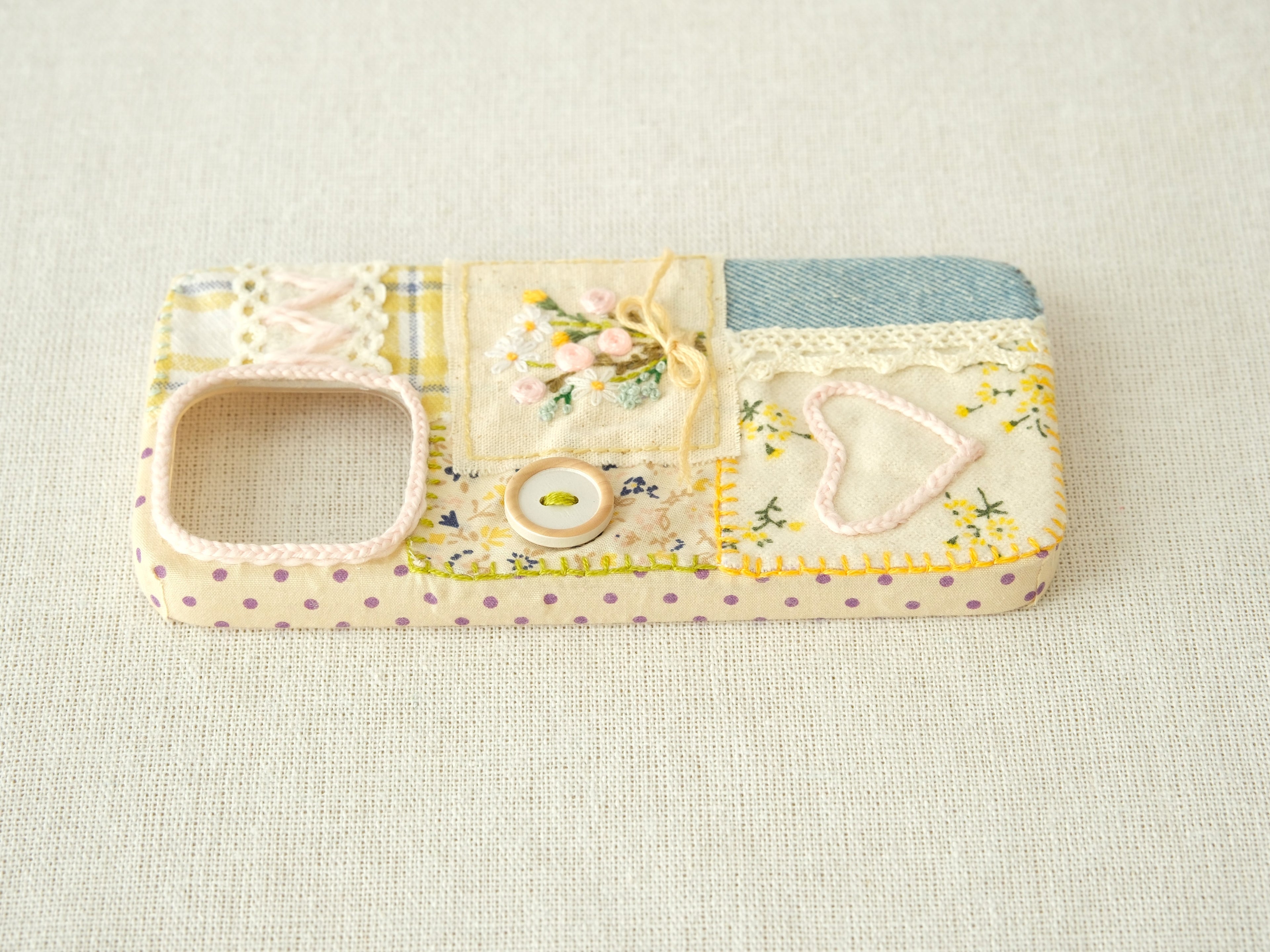 Side view of the patchwork case featuring purple polka dots and precise volume button access, artisanal style.