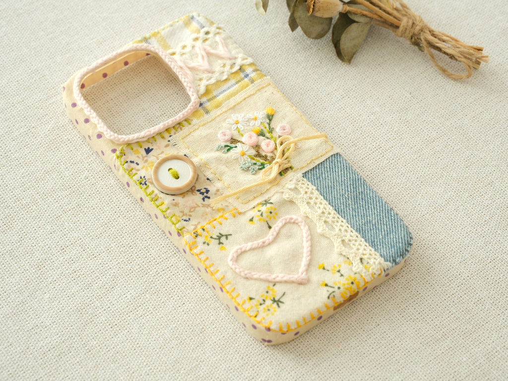 Side view of the "Floral Heart" patchwork case with embossed daisies and layered mixed-media fabrics.