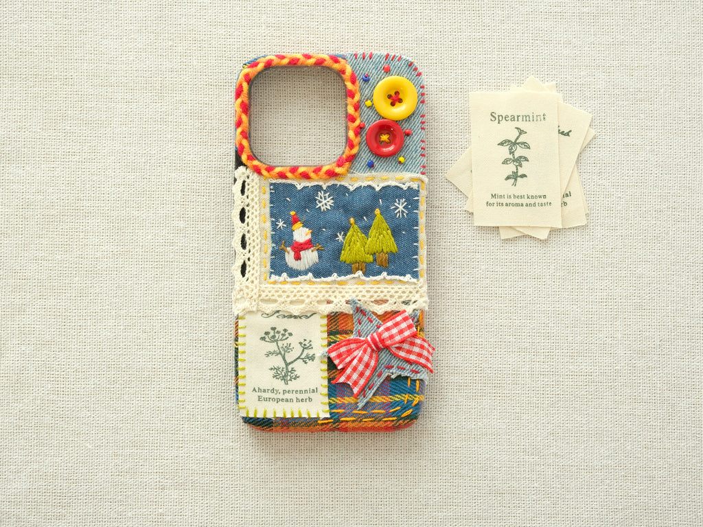 Artisanal patchwork case with a snowman and trees on a neutral linen background, vintage winter design.