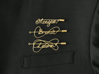 Custom name brooch in gold-plated copper wire on a black jacket, handcrafted jewelry.