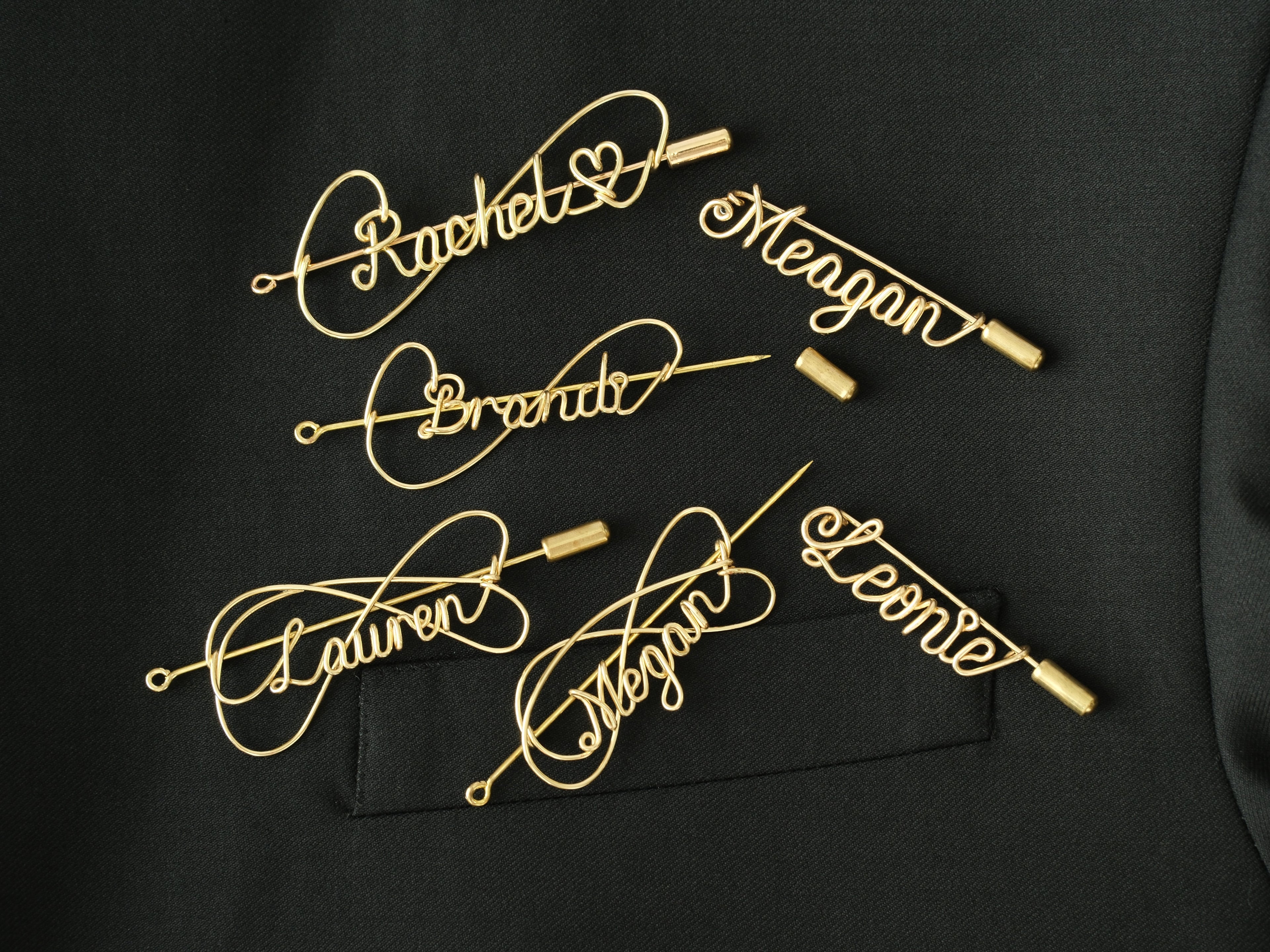 Collection of various custom name brooches in different artisanal styles and bespoke names.