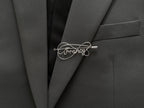 Personalized silver-plated name pin with an elegant double-intertwined line design on a dark green jacket.