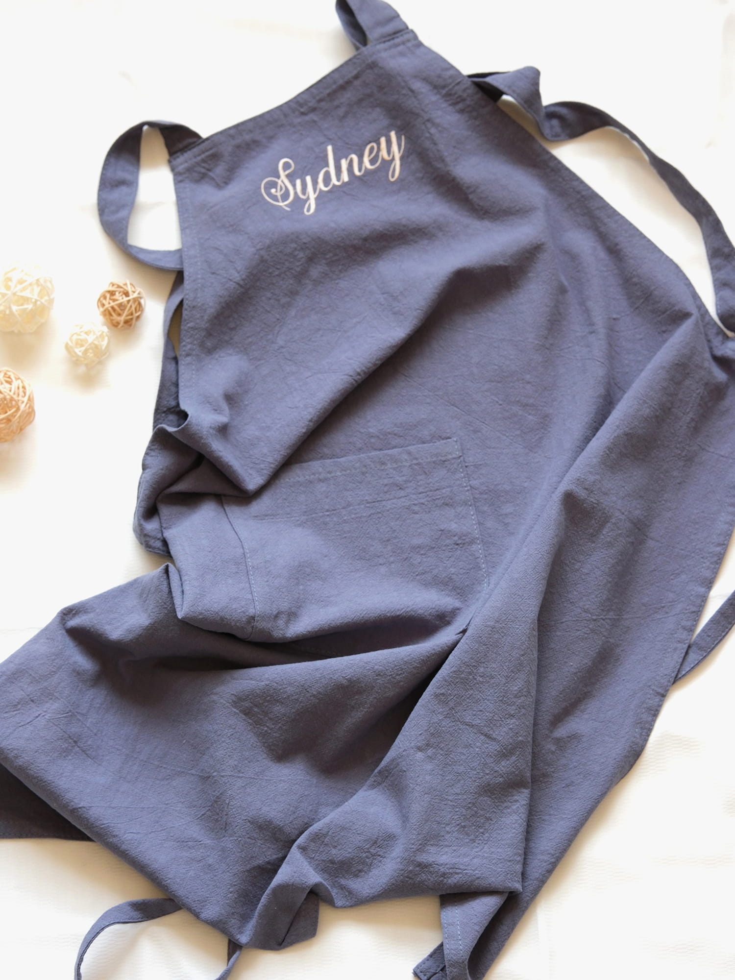 Slate Blue linen apron personalized with "Sydney" embroidery and a spacious central pocket.