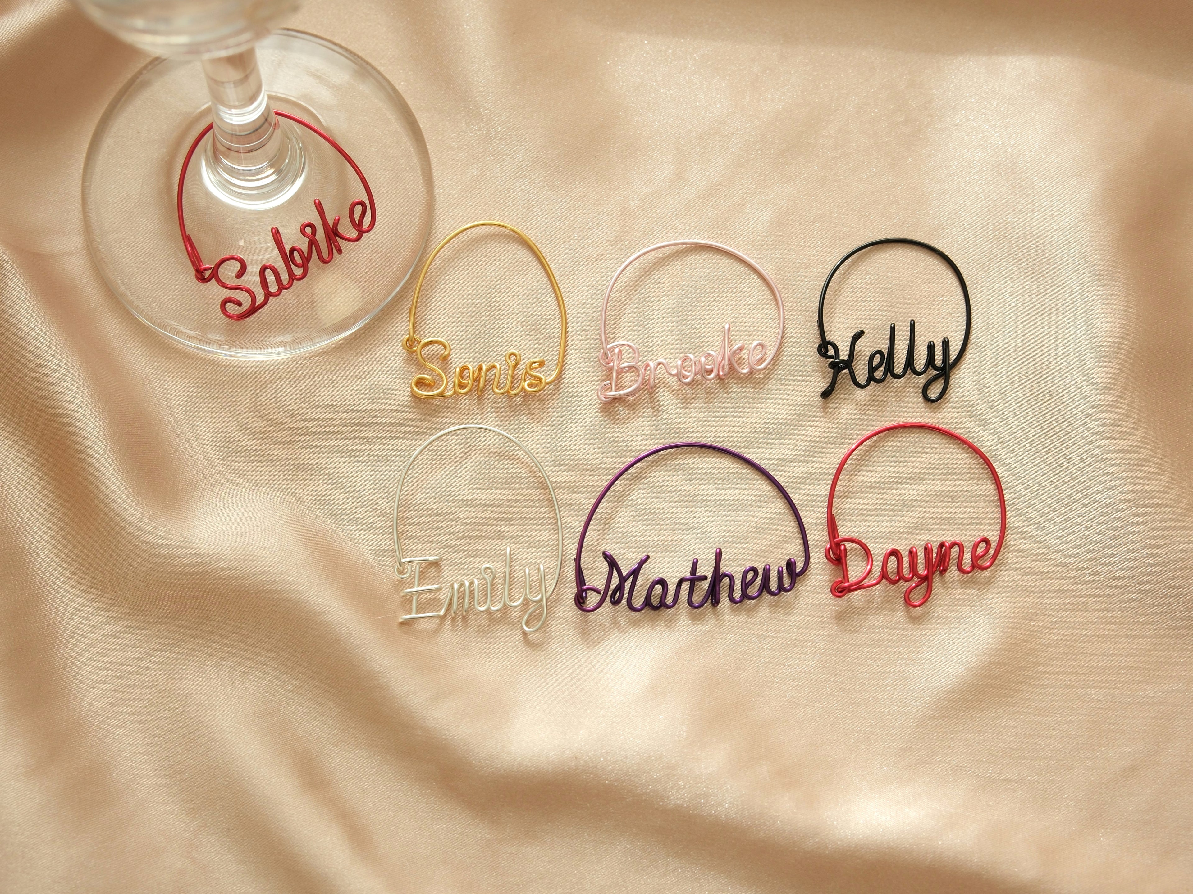 Overview of all available colors for personalized wine glass charms, including gold, silver, pink, and purple.