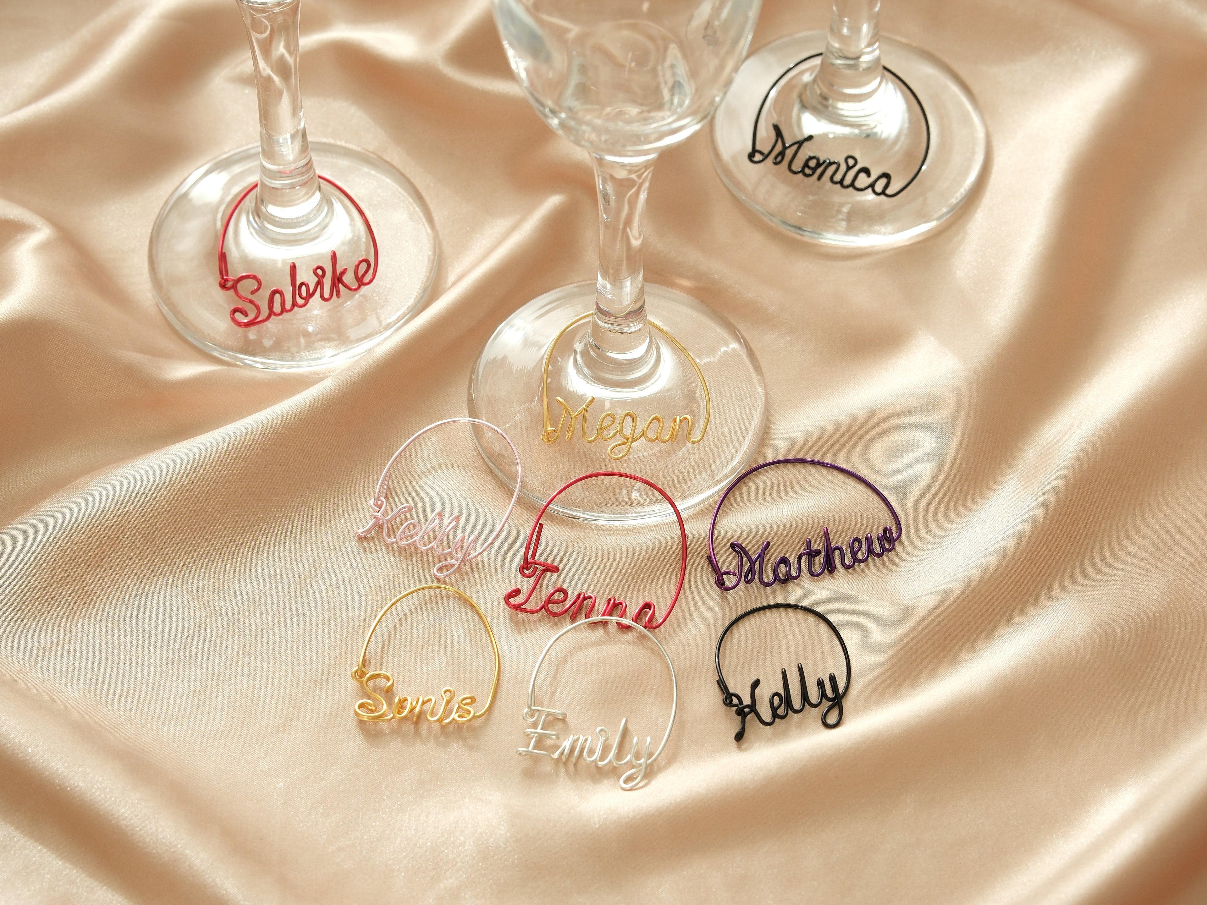 Collection of personalized wine glass charms in various colors, ideal for weddings and private parties.