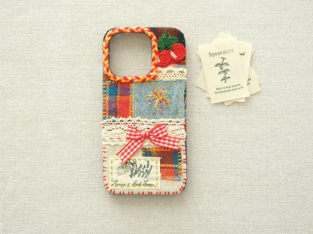 Artisanal patchwork case with cherries and fireworks on a neutral background, unique vintage design.