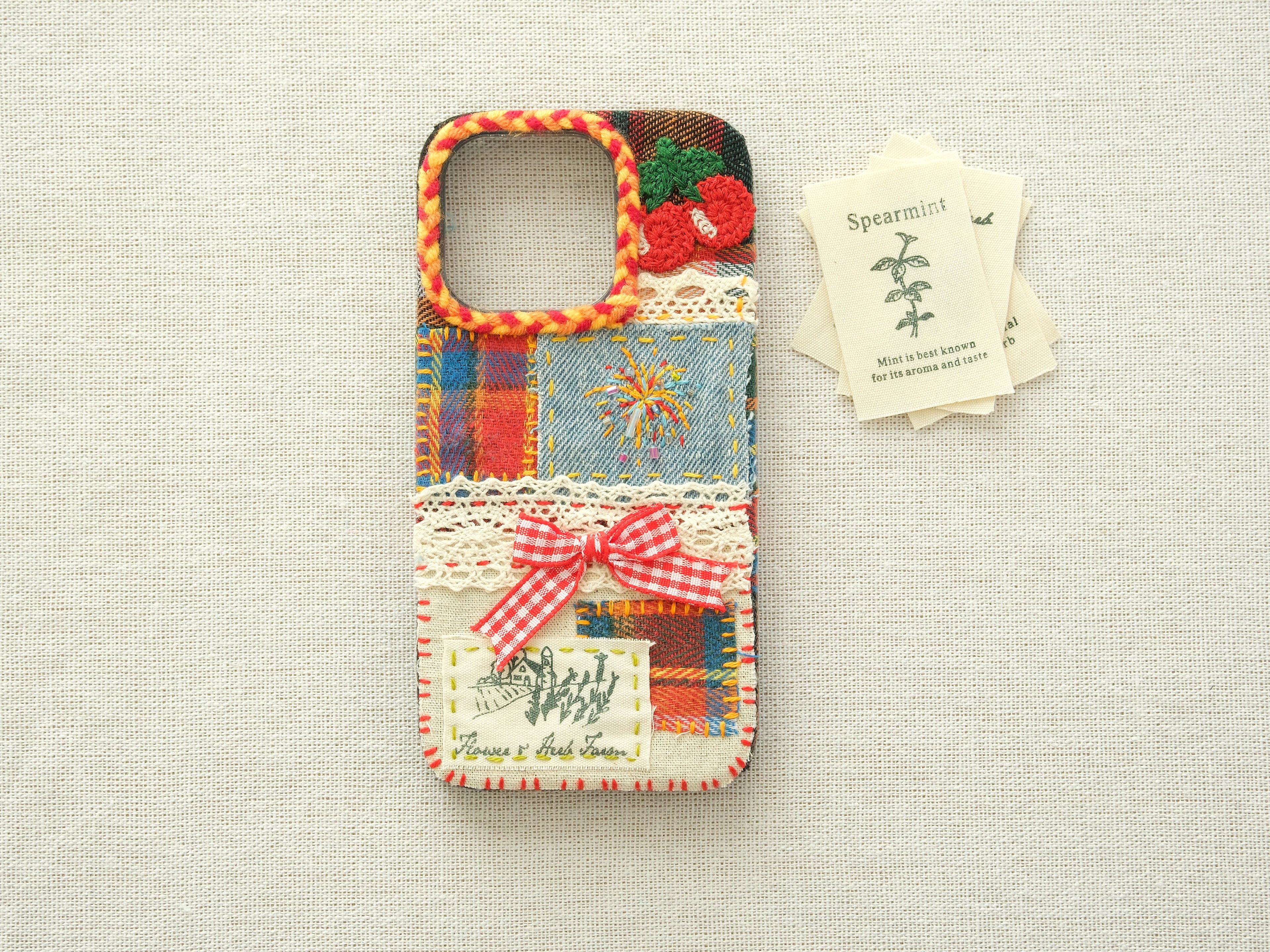 Artisanal patchwork case with cherries and fireworks on a neutral background, unique vintage design.